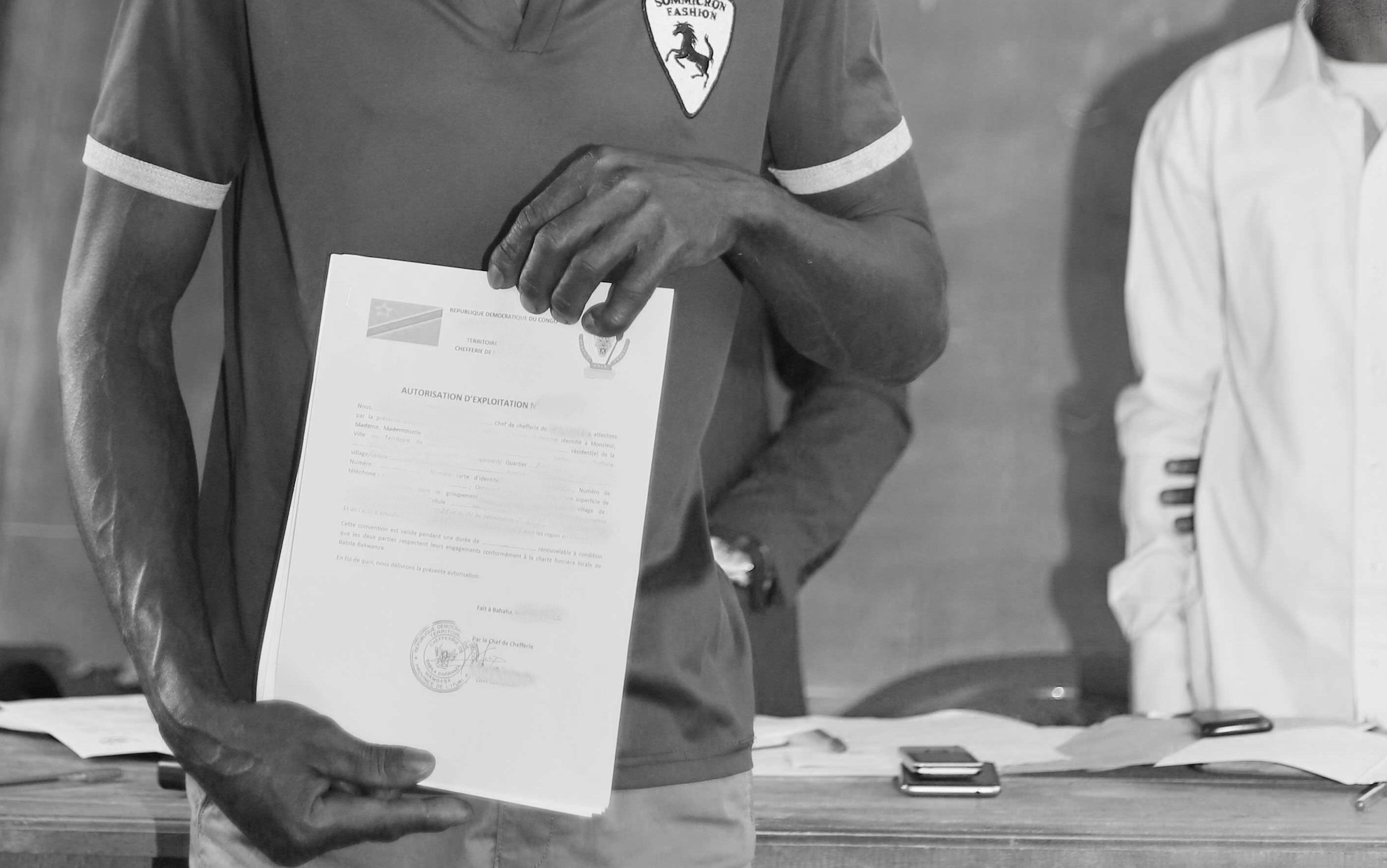 A man holds a land use certificate in his hands in DRC