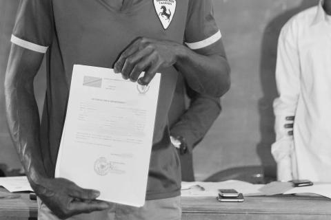 A man holds a land use certificate in his hands in DRC